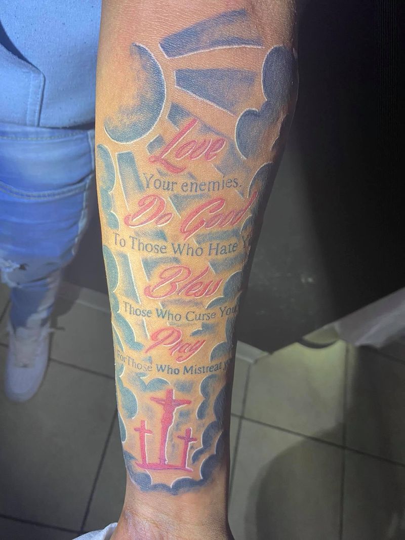 Forearm tattoo of red script lines set among clouds and a sun, with a trident at the bottom.