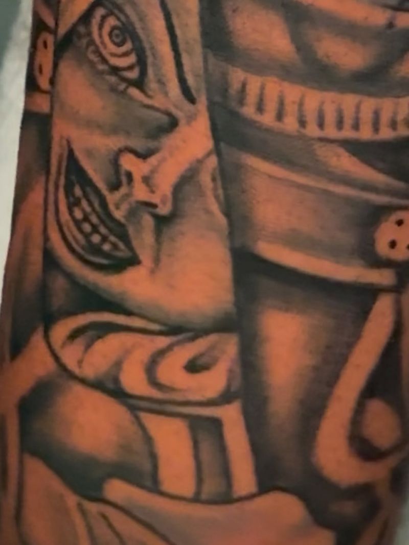 Close-up of a black and grey tattoo showing smooth shading on a masked figure.